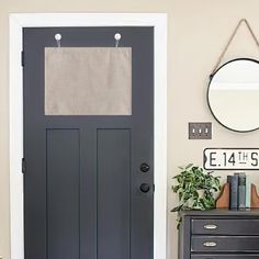 there is a black door and mirror in the room that has a clock on it