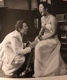 an old black and white photo of a man kneeling down next to a woman in a wedding dress