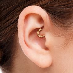 a woman's ear is shown with a gold nose ring