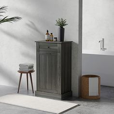 a bathroom with a sink, toilet and bathtub next to a potted plant