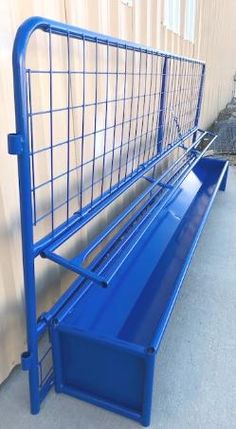 a blue metal bench sitting next to a building