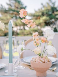 the table is set with flowers and wine glasses