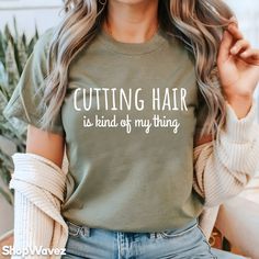 a woman wearing a t - shirt that says cutting hair is kind of my thing