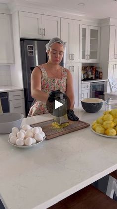 a woman in a kitchen preparing food on a cutting board with eggs and lemons