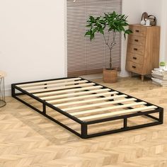 a bed frame with wooden slats on the bottom is shown in an empty room