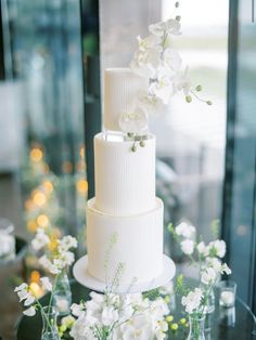 a three tiered white wedding cake with flowers