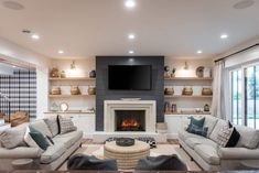 a living room filled with furniture and a flat screen tv mounted on the wall above a fire place