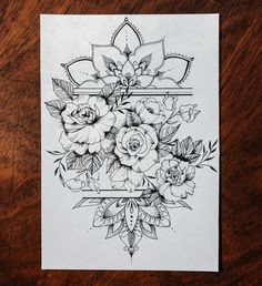 a black and white drawing of flowers on a piece of paper with an ornate border