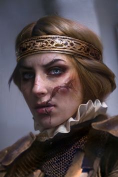 a close up of a person wearing a costume and headband with blood all over her face