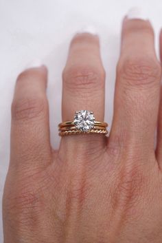 a woman's hand with a ring on it and a diamond in the middle