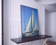 a sailboat poster hangs on the wall next to a table