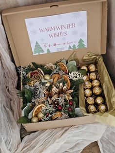 a box filled with assorted chocolates on top of a white cloth covered floor