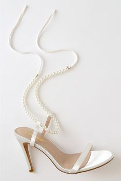 Lulus Exclusive! The Lulus Letzy White Satin Pearl Lace-Up High Heel Sandals are the perfect amount of glam! Sleek satin shapes these classic heels that have an open toe and a slender toe strap. A strand of faux pearls loops through two supportive straps before wrapping around and tying above the ankle. Stiletto heel. Pearl Ankle Strap Heels, Rehersal Dinner Shoes, Bride Shoes Pearls, Lace Up Wedding Shoes, Prom Shoes Pearl, Heels With Pearl Strap, White Prom Heels Classy, White Pearl Heels Bridal Shoes, Wedding Shoes Pearls High Heels