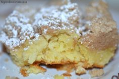 a close up of a doughnut on a plate with powdered sugar and crumbs