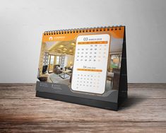 a desk calendar sitting on top of a wooden table