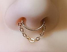 an ear piercing is shown with gold chains