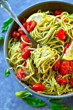 a bowl full of pasta with tomatoes and basil