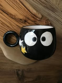 a black and white coffee cup with googly eyes