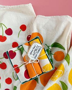 two oranges are wrapped in white paper and tied with twine