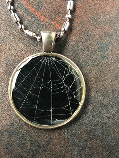 a necklace with a spider web design on it