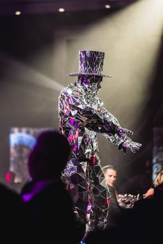 a man in a top hat and suit on stage