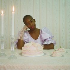 a woman sitting at a table in front of a cake