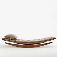 a wooden chaise lounge chair with pillows on the back and seat cushion, in front of a white background