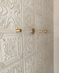 an ornate white wall with gold handles and knobs