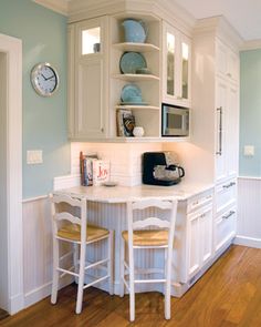 a kitchen with white cabinets and wooden floors