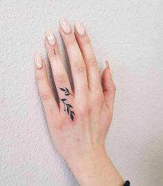 a woman's hand with a small tattoo on it