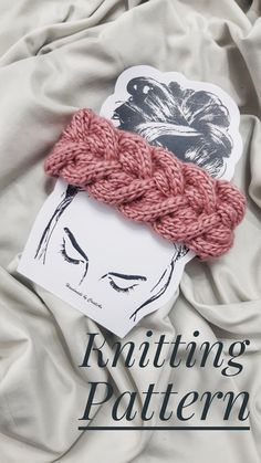 the knitting pattern is laying on top of a bed with white sheets and pink yarn