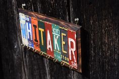 a wooden door with a sign on it that says taker and is hanging from the side