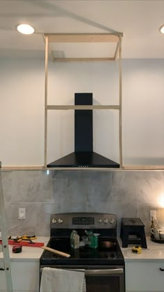 a stove top oven sitting inside of a kitchen next to a wall mounted range hood