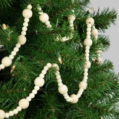 a close up of a christmas tree with ornaments on it's branches and the word love spelled by beads