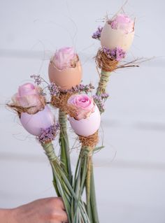 a person holding flowers with eggs in them