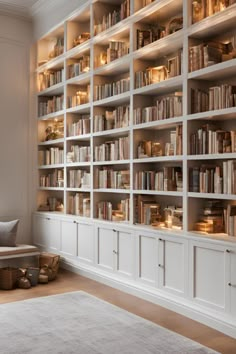 a room filled with lots of white bookshelves next to a wall full of shelves