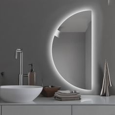 a white sink sitting under a bathroom mirror next to a wall mounted faucet