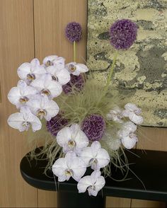 some white and purple flowers on a black table