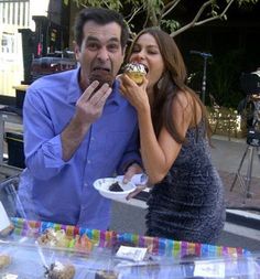 a man and woman eating desserts at an outdoor event