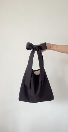 Black shoulder bag with tie-up closure and bow on the shoulder. Adjustable straps. You can wear this bag on your shoulder or as a crossbody bag. You can tie the bow on the shoulder or across your chest. Made from organic vintage cotton. This bag is attributed to its timeless, versatile design. It would look cute with any outfit. It's sustainable and chic, with retro aesthetics. We use our own patterns and designs. We only use non-toxic, longevity organic fabrics to last a lifetime. Most of our f Bow Aesthetic Outfit, Vintage Bag Aesthetic, Bags With Bows, Bow Tote Bag, Vintage Style Bag, Bow Bag, Handbag Pattern, Bags Aesthetic, Jewelry Lookbook