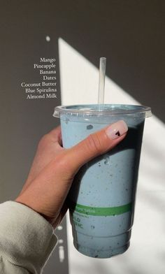 a hand holding a cup with a straw in it