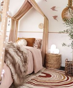 a bedroom with a canopy bed, rugs and pillows on the floor in front of it