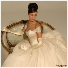 a woman in a white dress sitting on a chair