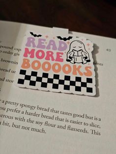 an open book with a sticker on it that says read more books and checkered squares