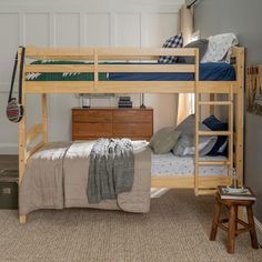 a bunk bed sitting in the middle of a bedroom next to a dresser and chair