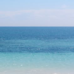 two people walking on the beach with an umbrella