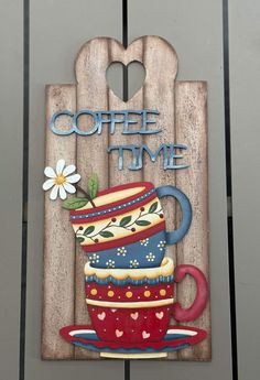 a wooden sign that says coffee time with a stack of teacups on it