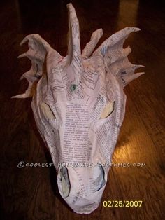 an origami dragon head made out of newspaper