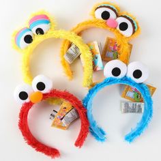 three sesame street characters headbands with googly eyes and hair clips on them