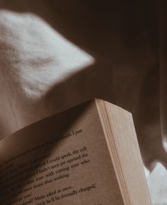 an open book sitting on top of a bed